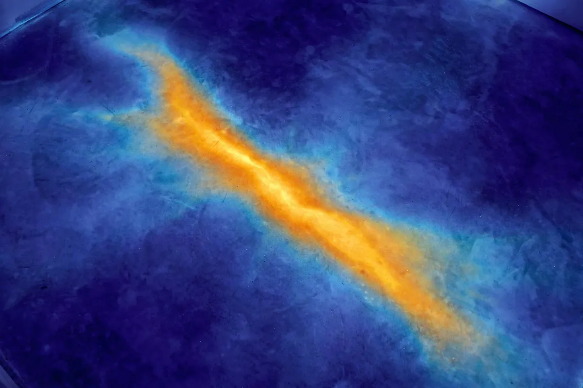 Thermal image of a warm plume on a floor marking a slab leak